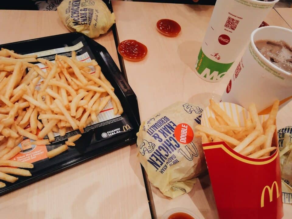 A imagem mostra um combo de lanches do McDonald's. Com batata frita, hambúrguer e refrigerante. 