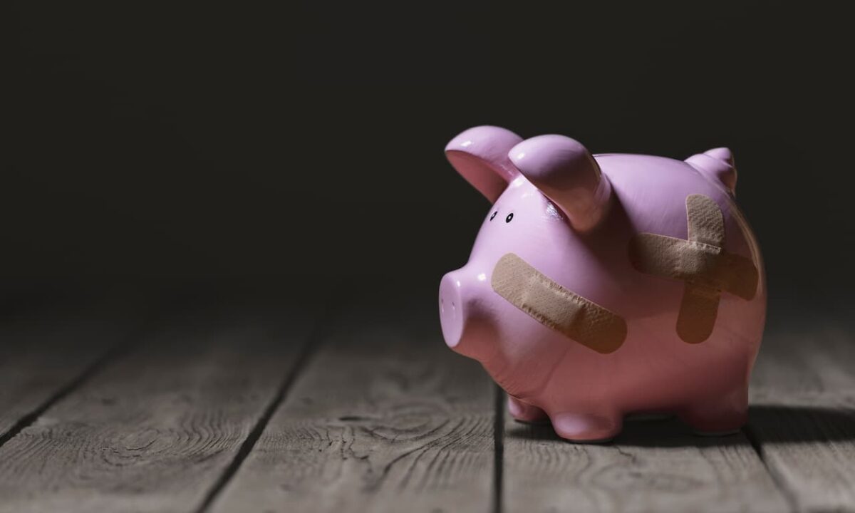 Cofre de porquinho machucado simbolizando risco de falência.