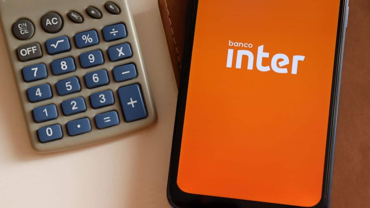 Celular com a logo do Banco Inter e uma calculadora