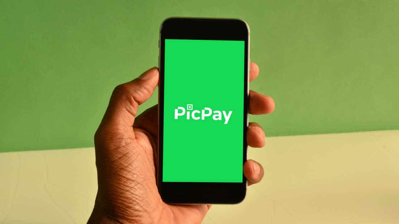 Mão segurando celular com app do PicPay aberto