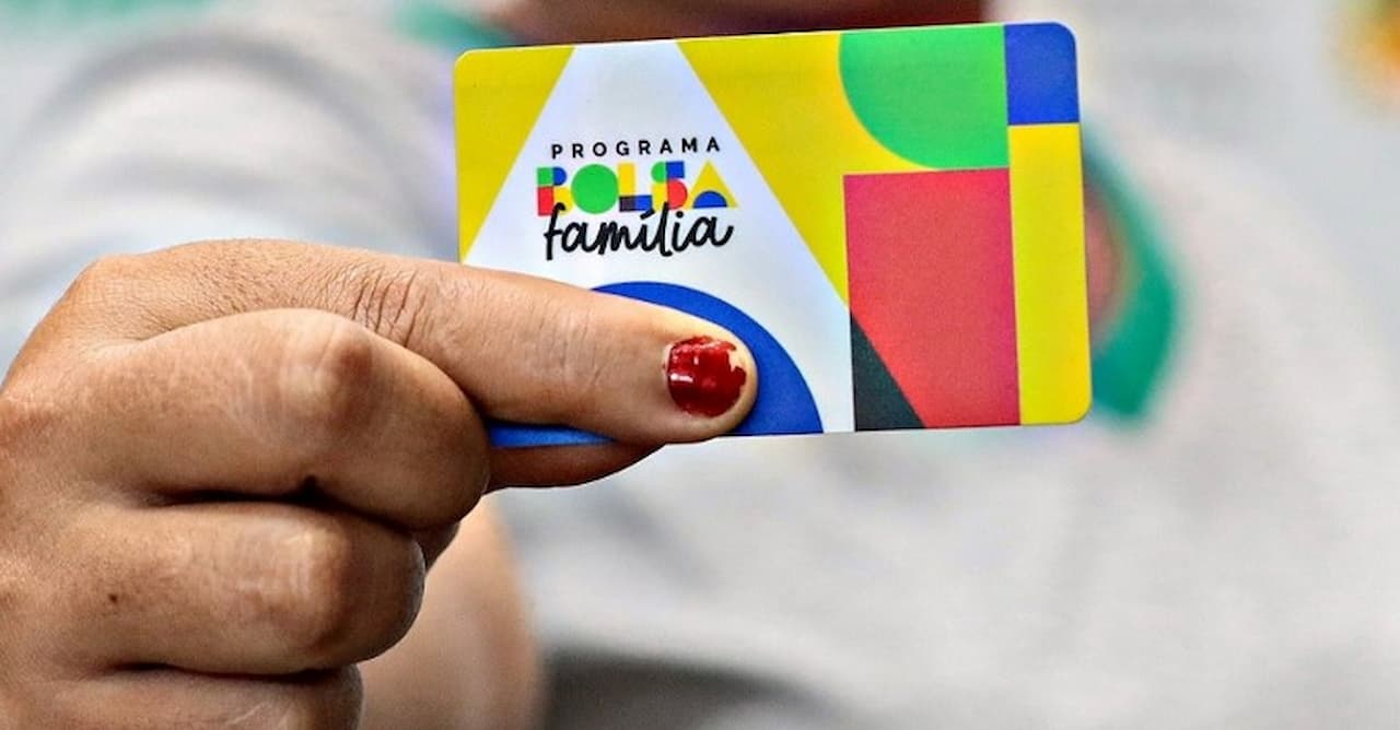 Na imagem, mão segurando o novo cartão do Bolsa Família.