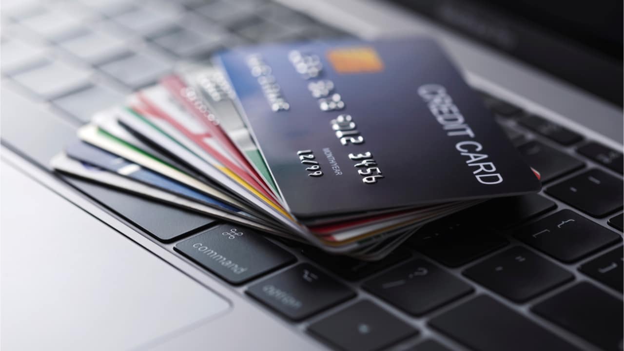 Diversos cartões de crédito que sofrerão mudanças empilhados sobre um teclado
