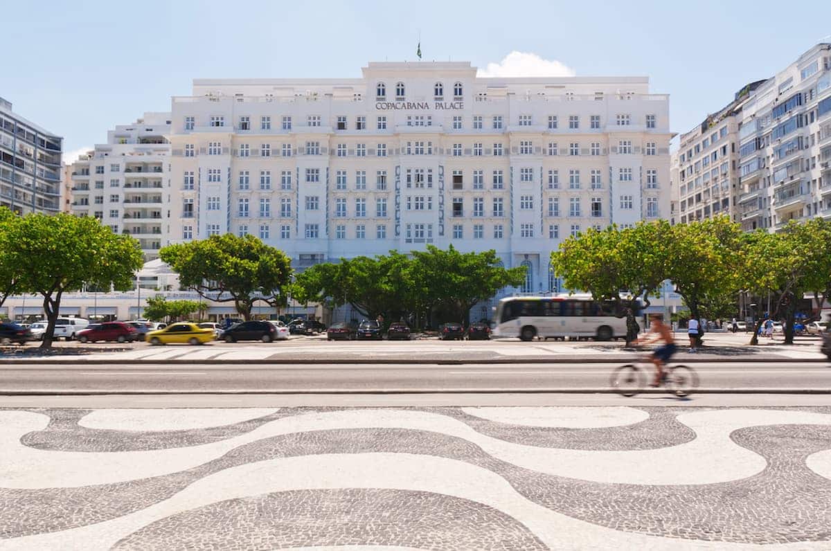 Imagem do hotel Copacabana Palace visto da calçada da praia.