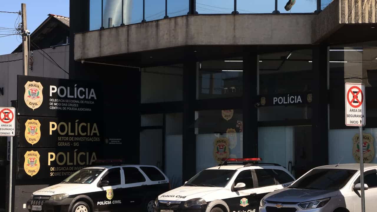 Fachada de uma delegacia da polícia civil em São Paulo. Viaturas paradas na frente
