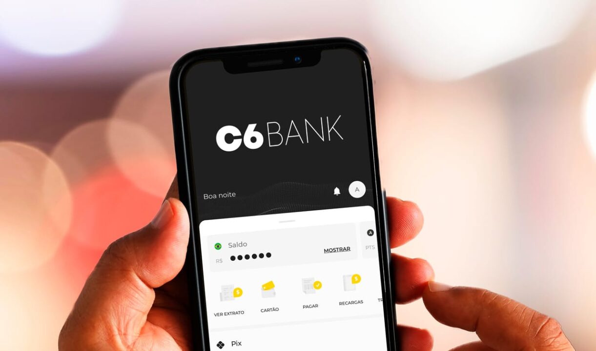 imagem de uma mão segurando um celular com o aplicativo do C6 Bank