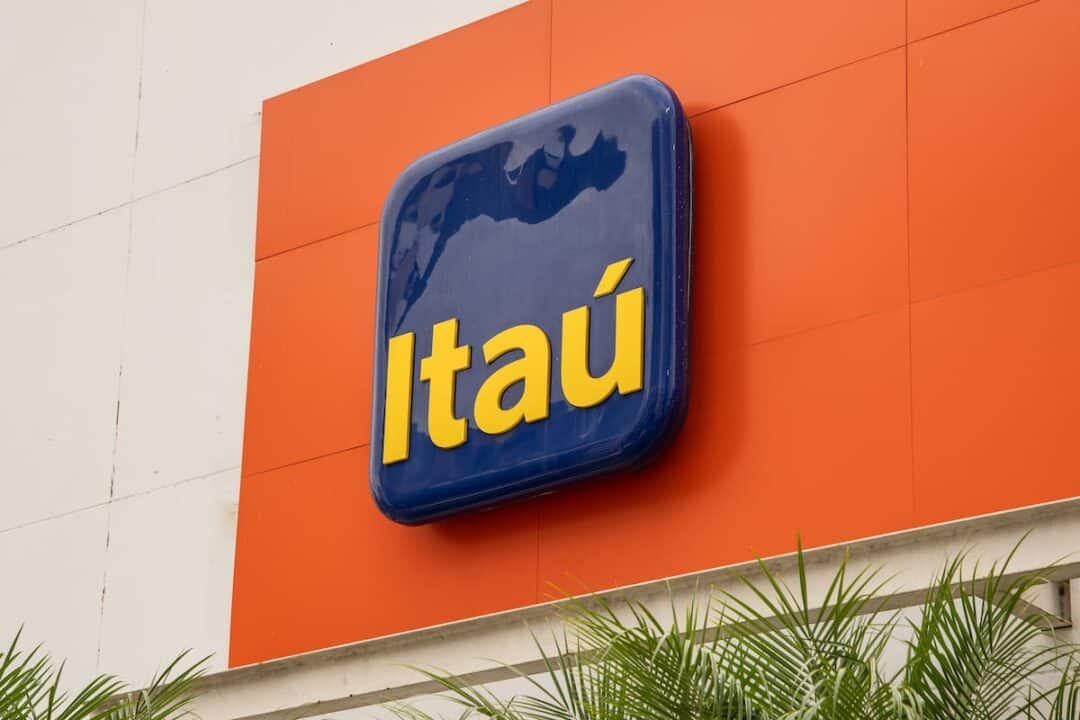 Placa com logo do Itaú em fachada do banco.