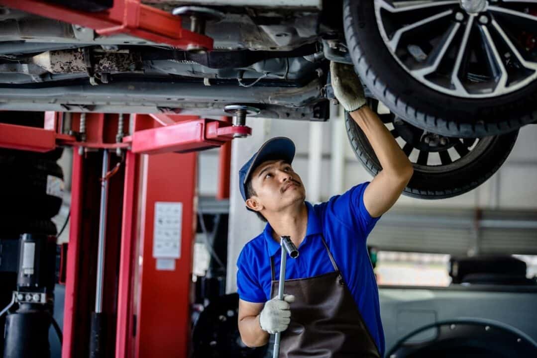 Homem fazendo reparos em um carro.