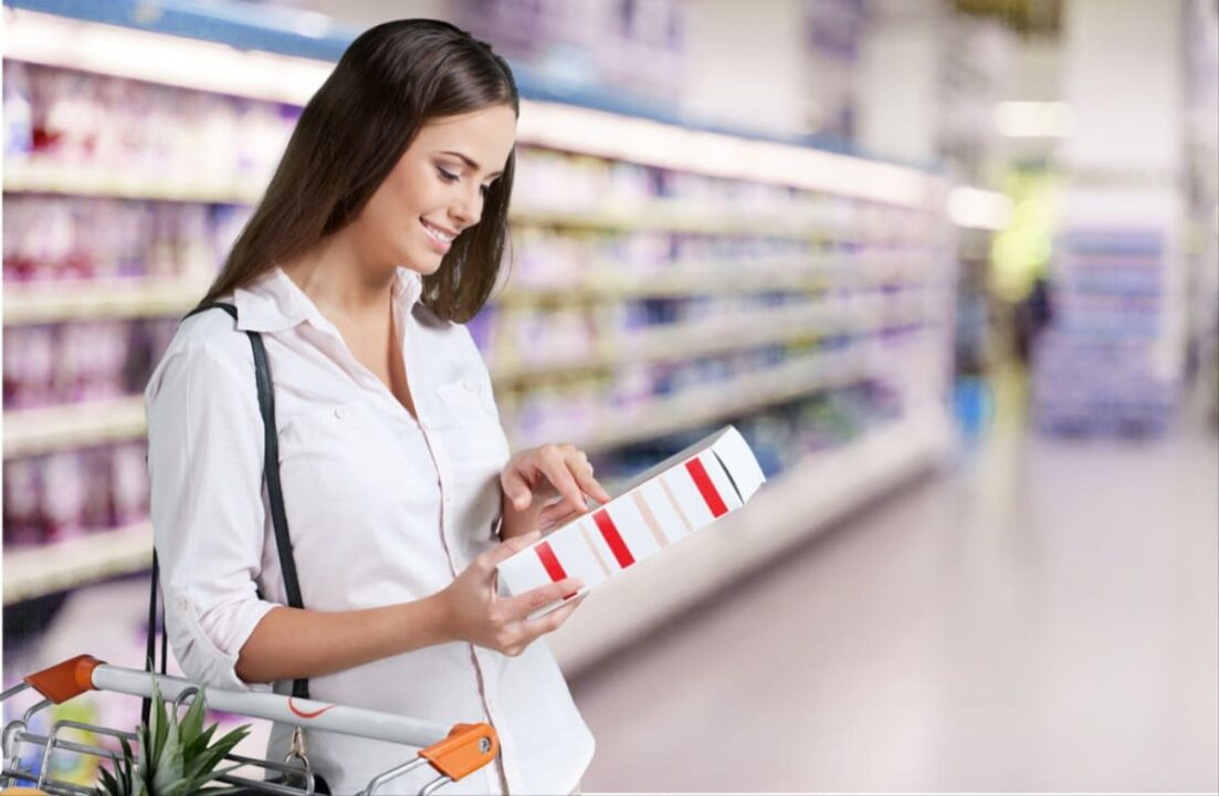 Mulher lendo embalagens de produtos no supermercado