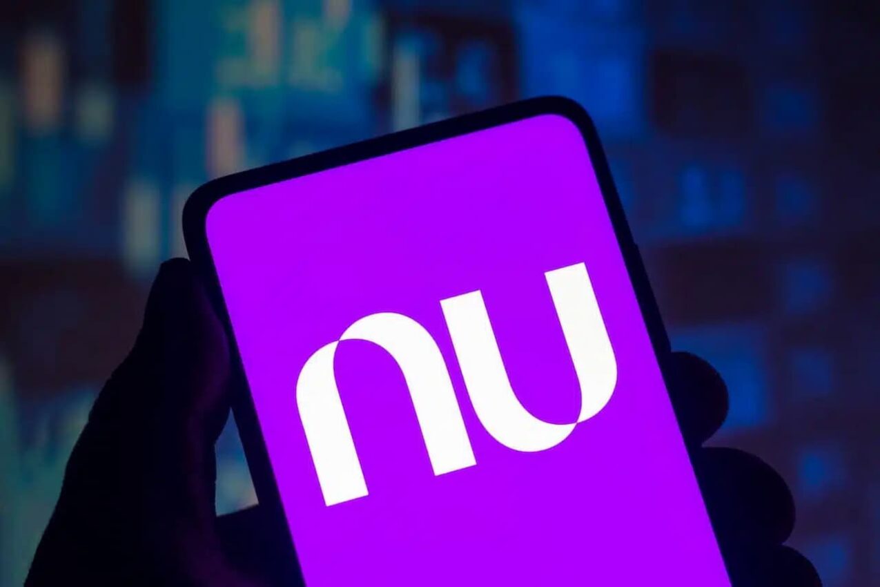 Imagem de um celular com o logotipo do aplicativo do Nubank na tela. O fundo da tela é roxo e as letras 'NU' aparecem em branco.