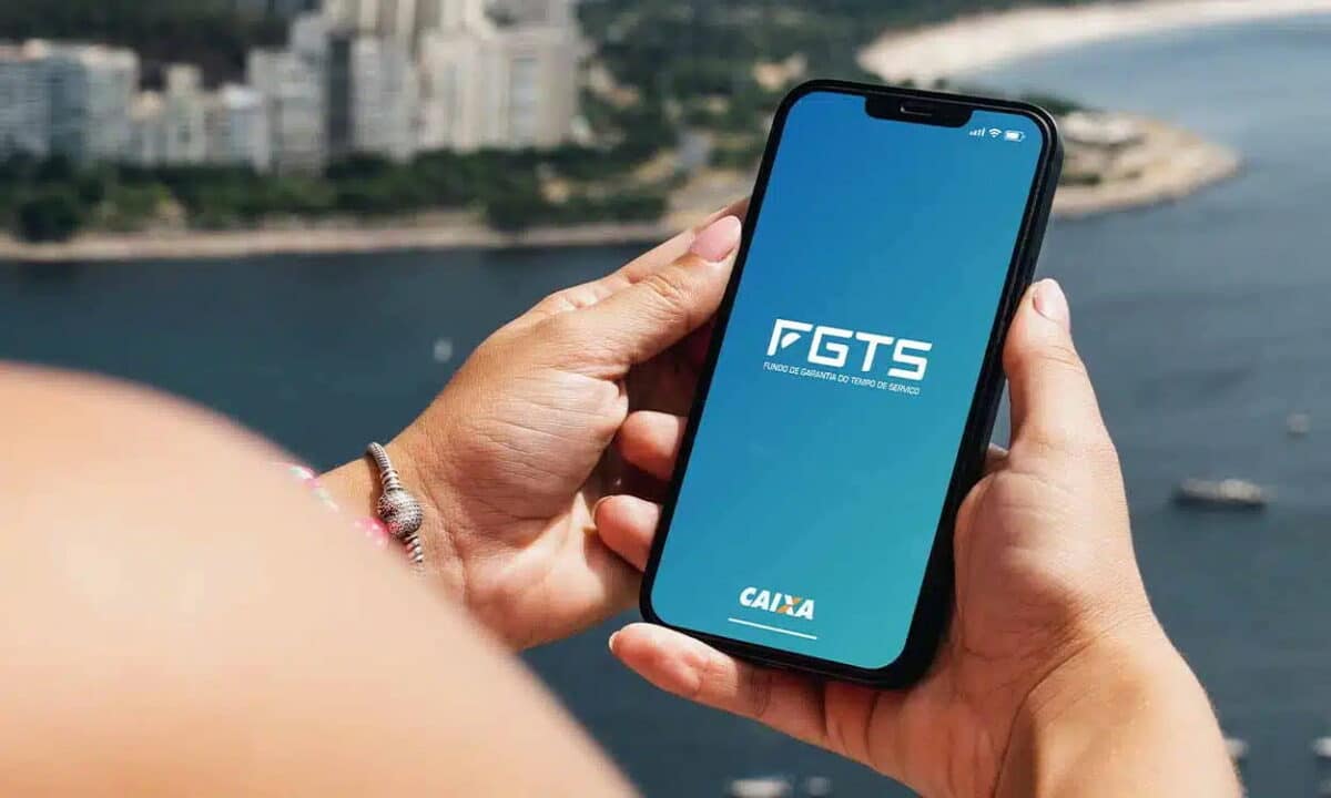 Mão segurando celular com o app do FGTS aberto