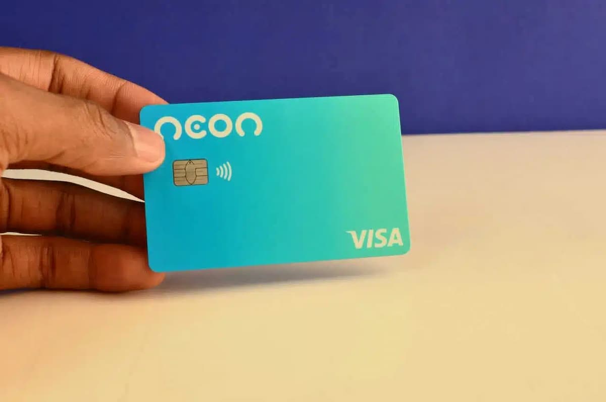 Mão segurando um cartão de crédito da Neon.