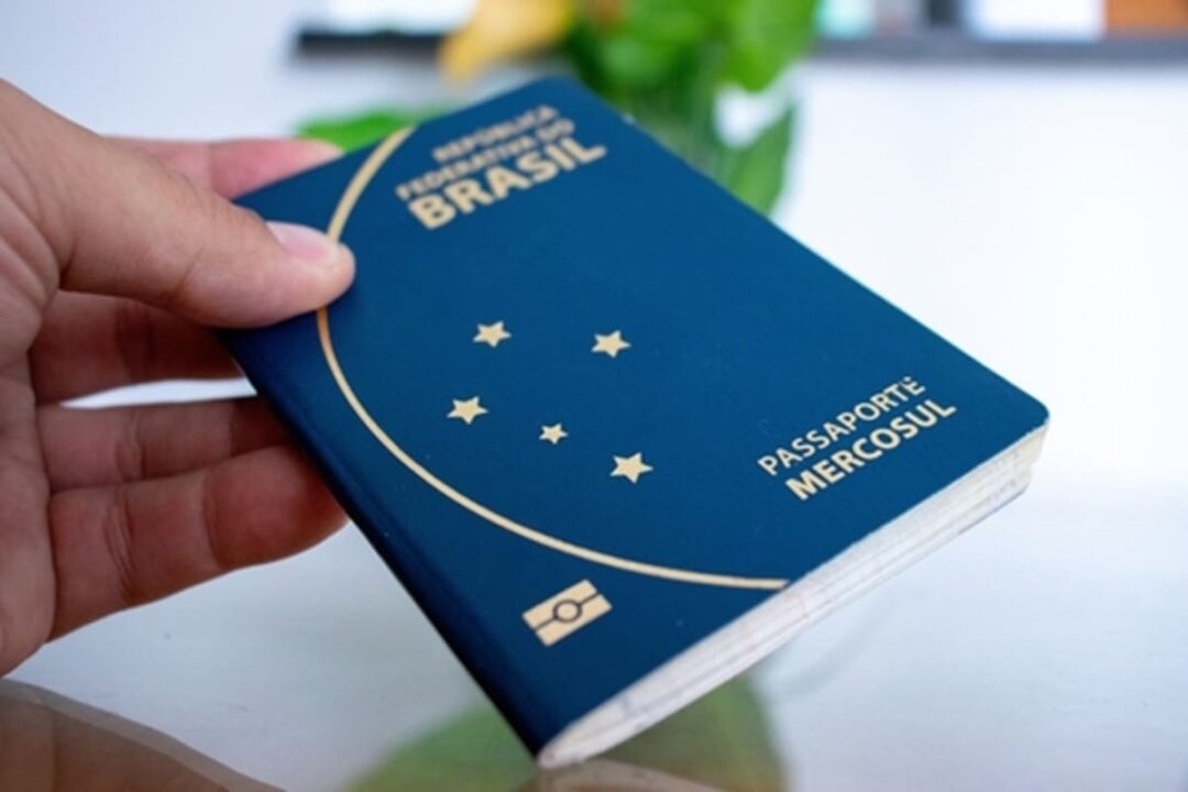 Pessoa segurando um passaporte brasileiro