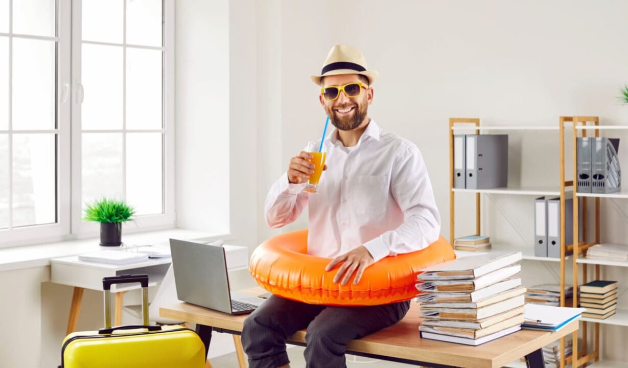 Homem com boia e óculos de sol sentado em cima de mesa de escritório
