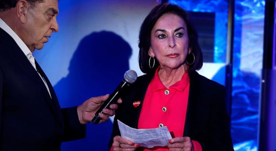 Foto do Facebook de Iris Fontbona, de vermelho e com um papel nas mãos