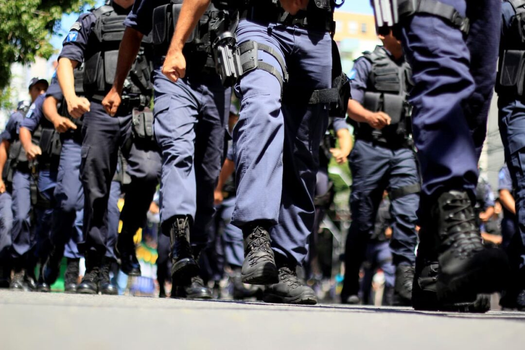 Policiais militares marchando. Foto das pernas 