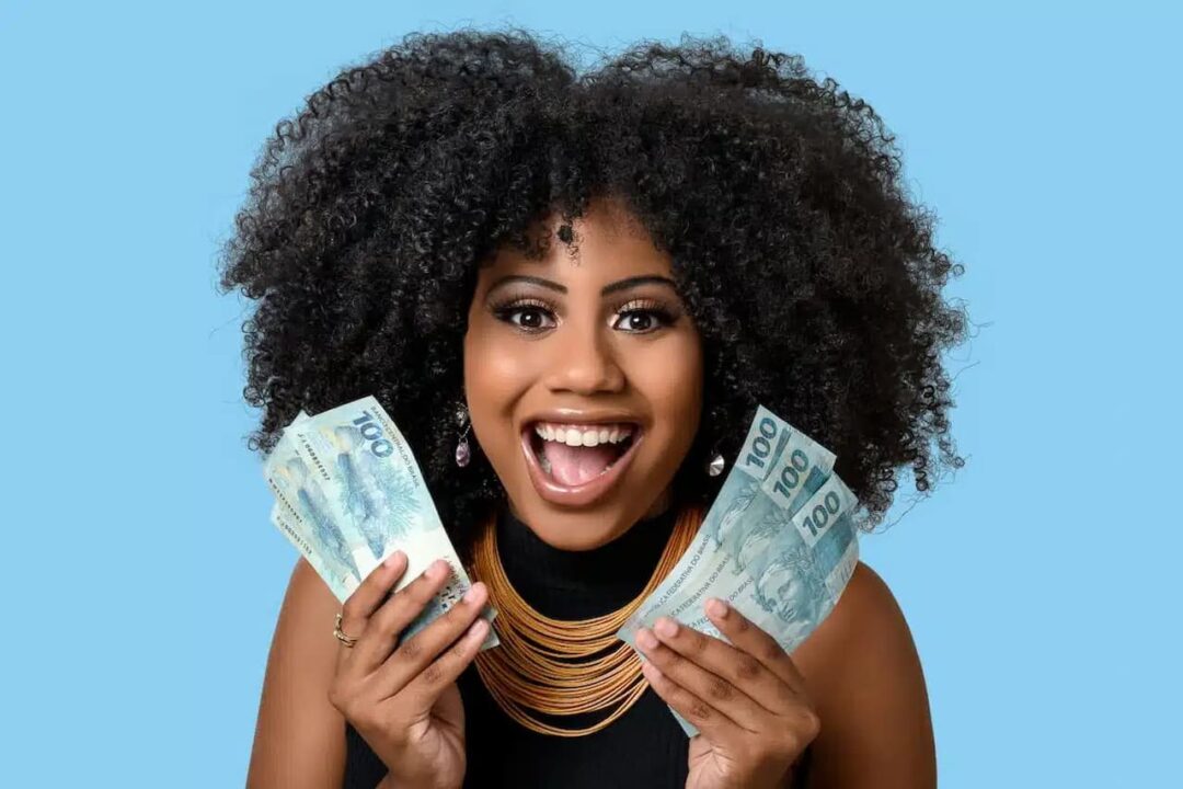 Mulher segurando notas de dinheiro e sorrindo
