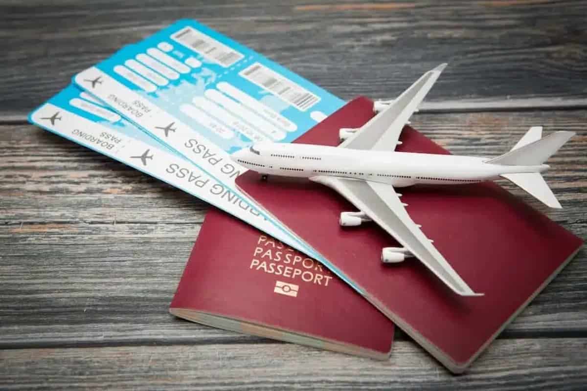 Passagens, passaportes e miniatura de avião.