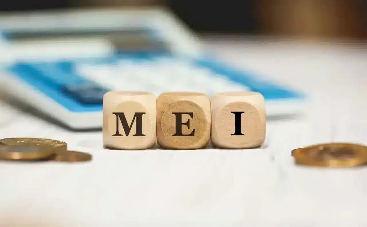 Quadradinhos de madeira com as letras "m", "e" e "i", formando a sigla MEI - Microempreendedor Individual