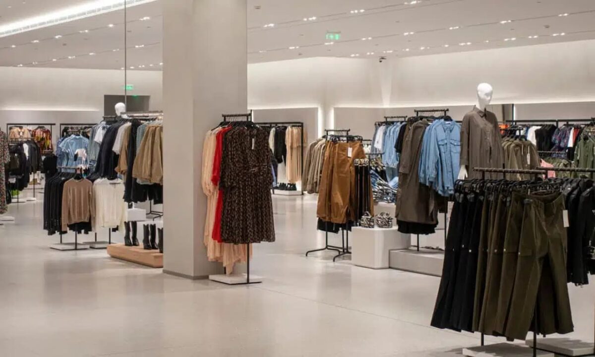 Interior de uma loja de uma empresa da moda, com roupas expostas em várias araras