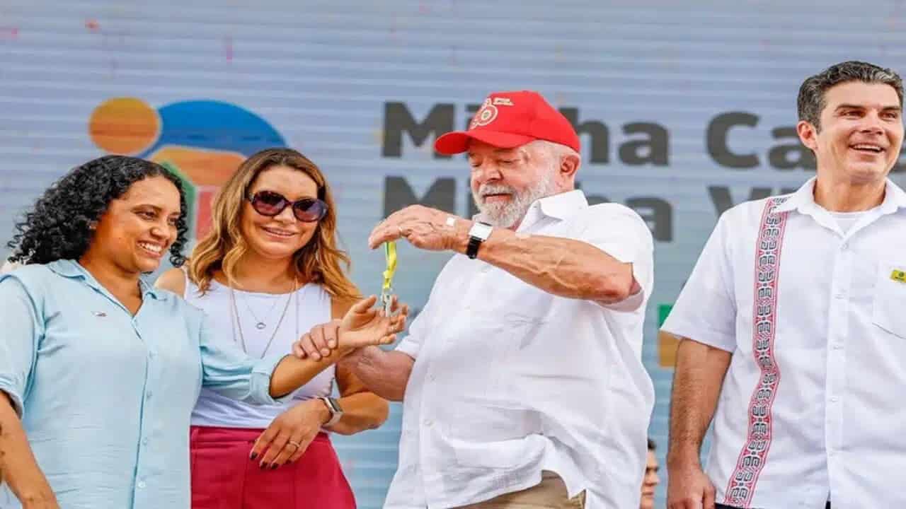 Presidente Lula entregando chave de casa nas mãos de uma mulher