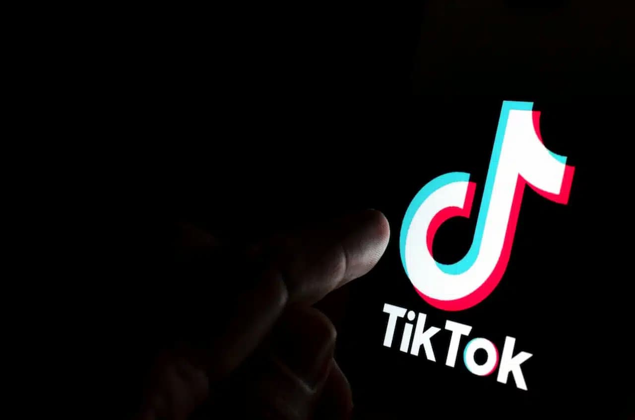 Dedo clicando sobre logotipo do TikTok