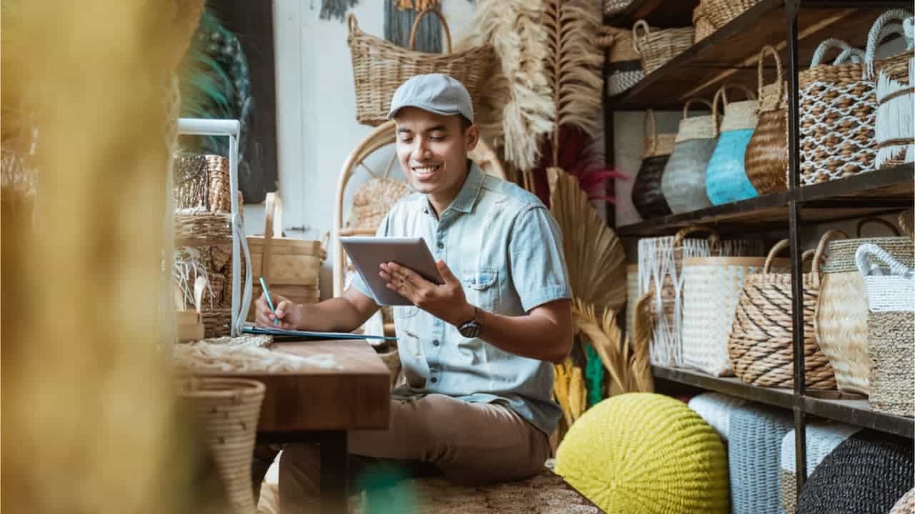 Homem sorrindo enquanto olha para tablet
