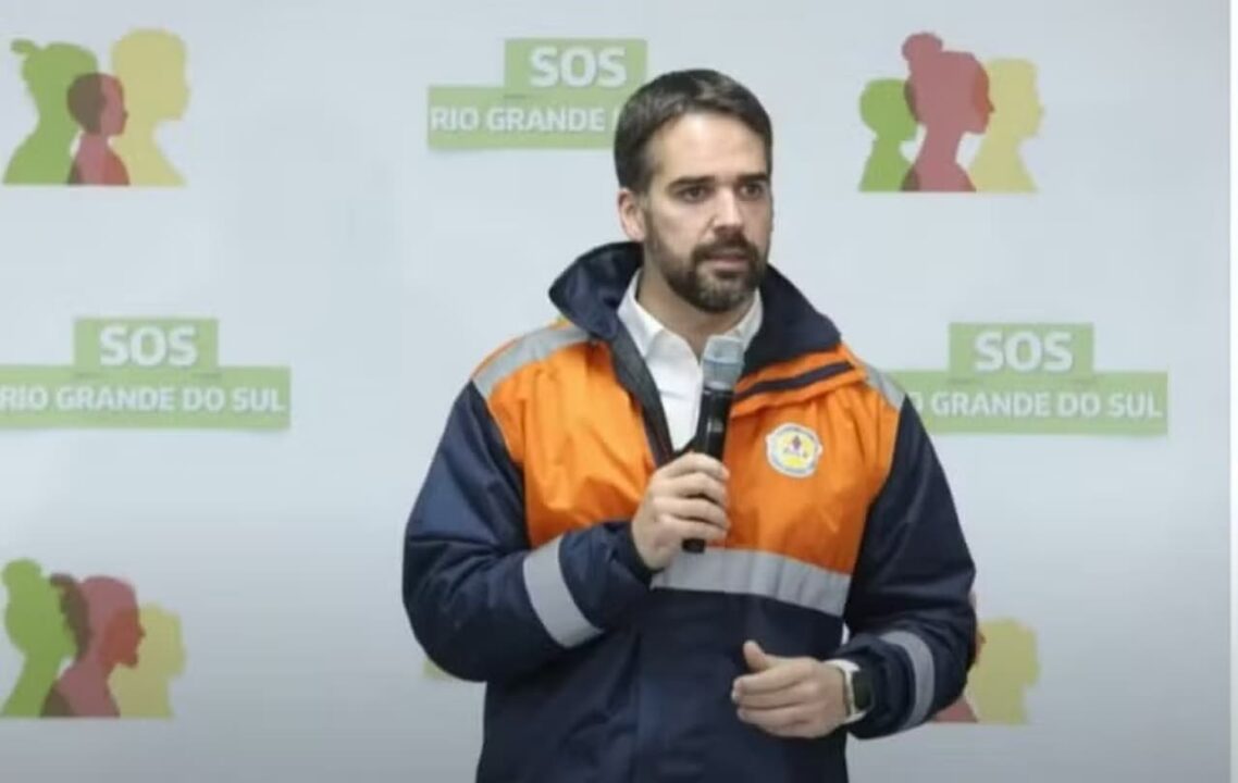 Imagem do governador do Rio Grande do Sul, Eduardo Leite, segurando um microfone