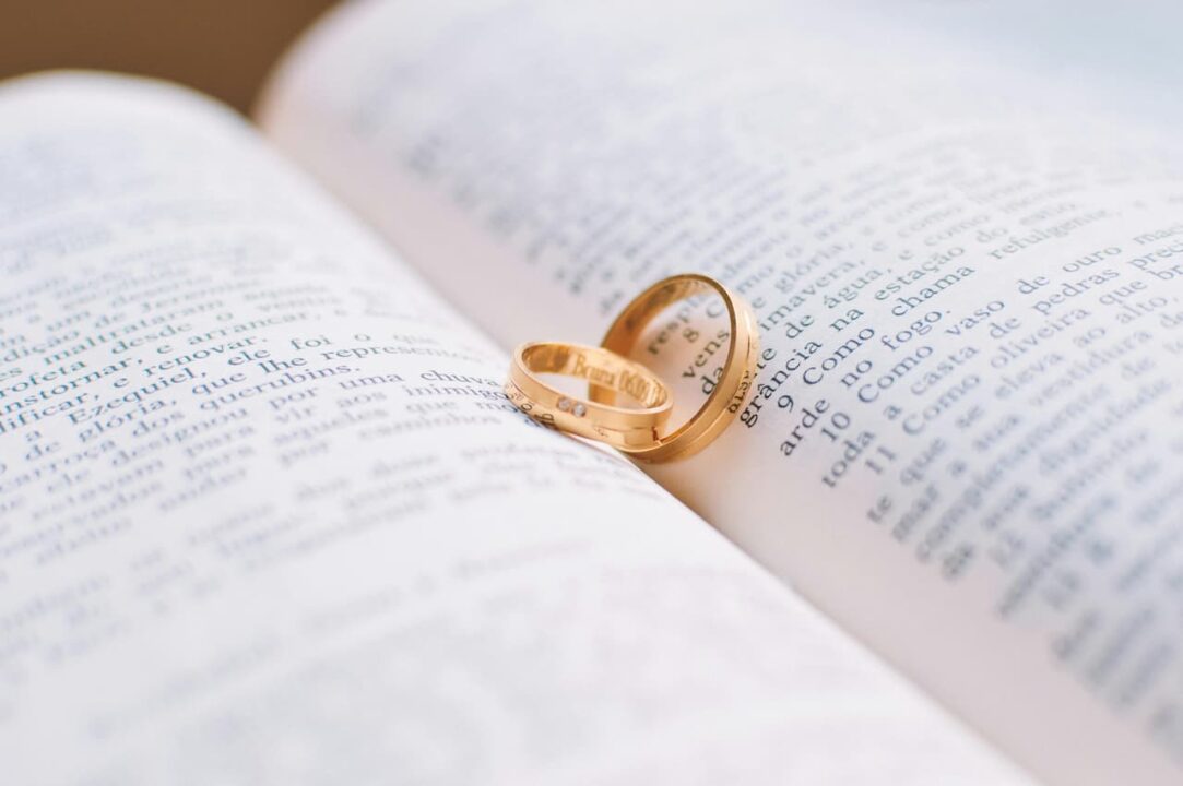 Imagem de duas alianças de casamento em cima de uma bíblia aberta