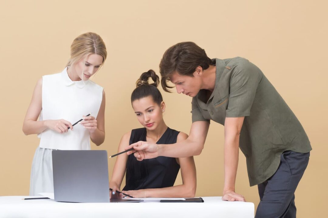 Três jovens olhando para a tela de um notebook